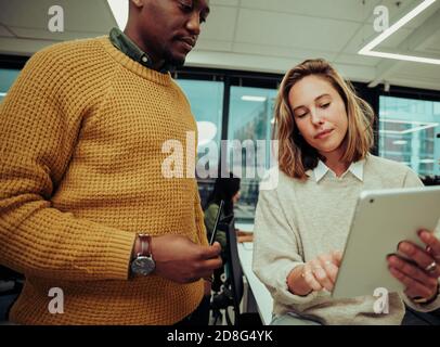 Verschiedene Kollegen arbeiten zusammen. Mixed Race männlichen Unternehmer und Designer arbeiten an Zusammenarbeit Projekt sitzen im Büro Stockfoto