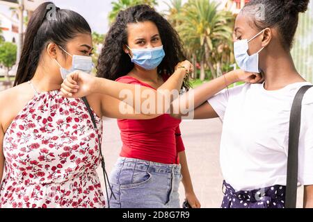 Junge Mädchen tragen Gesichtsmaske tun neue soziale Distanzierung begrüßen mit Ellbogen zur Verhinderung Corona Virus Ausbreitung. Covid 19 und Freundschaftskonzept Stockfoto