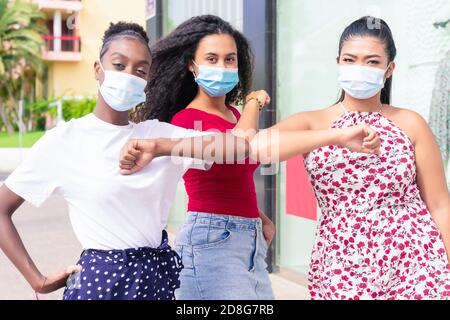 Junge Mädchen tragen Gesichtsmaske tun neue soziale Distanzierung begrüßen mit Ellbogen zur Verhinderung Corona Virus Ausbreitung. Covid 19 und Freundschaftskonzept Stockfoto