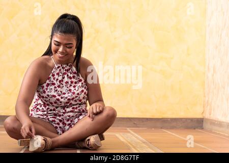 Porträt von glücklich junge asiatische Mädchen in guter Laune. Teenager sitzt auf dem Boden, träumen in etwas großes. Glückliche Frau verloren in ihren Gedanken. Stockfoto