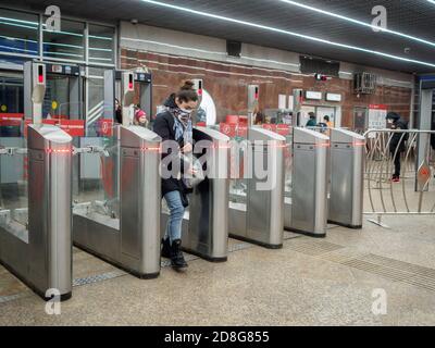 Moskau. Russland. 29. Oktober 2020. Passagiere passieren automatische Drehkreuze an der Moskauer U-Bahn-Station. Auf den Gesichtern der Menschen, Schutzmasken Stockfoto