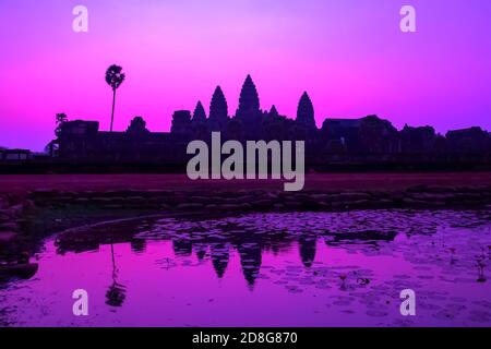 Schöne lila bunten Sonnenaufgang dramatischen Himmel am See heiligen Angkor Wat Fassade Silhouette, berühmtes Ziel in Kambodscha. Wunderschöner tropischer Sonnenaufgang Stockfoto
