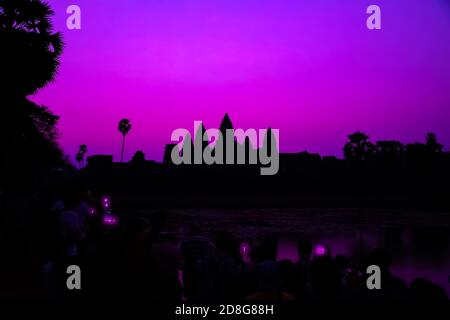 Tourist fotografieren Smartphone Angkor Wat Tempel romantische Sonnenaufgang Lila Silhouette Reflexion auf Wasser Teich Hintergrund. Heiliger Ort in Asain. Popul Stockfoto