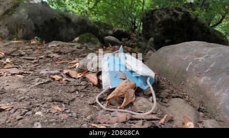 Bild einer Gesichtsmaske auf den Boden geworfen in Ein Park Stockfoto