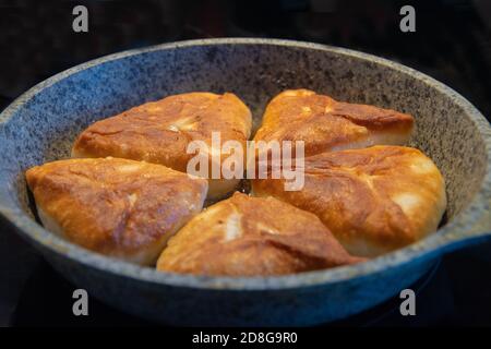 Graue Platte mit leckeren frittierten Kuchen auf schwarzem Hintergrund, isolieren Stockfoto