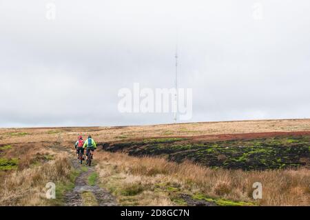 In ganz Großbritannien - EIN Paar Mountainbiker auf dem Weg in Richtung Winter Hill Sending Station, Winter Hill & Rivington Moor, Lancashire, Großbritannien Stockfoto