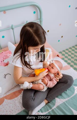 Kleines Mädchen spielen Fütterung ihr Baby Puppe Stockfoto