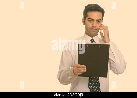 Junge persische Geschäftsmann Gespräch am Handy und lesen Zwischenablage Stockfoto