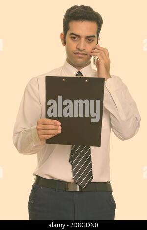 Junge persische Geschäftsmann Gespräch am Handy und lesen Zwischenablage Stockfoto