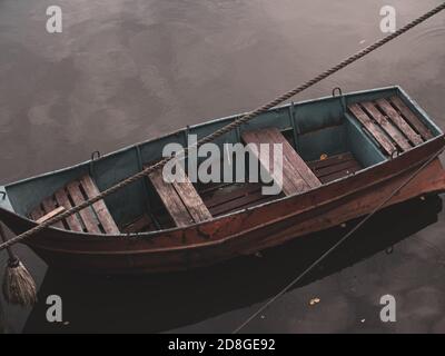 Holzboot, das mit dem Kabel ans Ufer festgemacht wurde Stockfoto