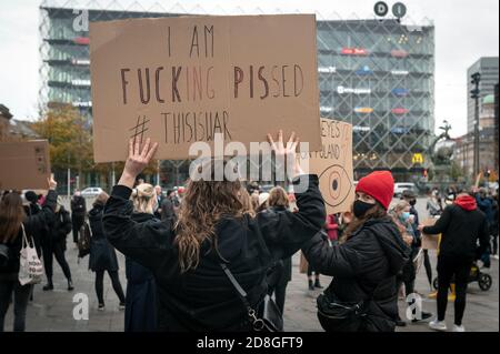 Kopenhagen, Dänemark. Oktober 2020. Polen in Dänemark und Unterstützer protestieren gegen das strenge Abtreibungsgesetz in Polen. Demonstranten halten Plakate mit Parolen hoch und tragen das rote Blitzbild, das zu einem Symbol der Proteste geworden ist. Stockfoto