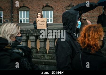 Kopenhagen, Dänemark. Oktober 2020. Polen in Dänemark und Unterstützer protestieren gegen das strenge Abtreibungsgesetz in Polen. Demonstranten halten Plakate mit Parolen hoch und tragen das rote Blitzbild, das zu einem Symbol der Proteste geworden ist. Stockfoto