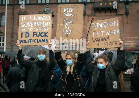 Kopenhagen, Dänemark. Oktober 2020. Polen in Dänemark und Unterstützer protestieren gegen das strenge Abtreibungsgesetz in Polen. Demonstranten halten Plakate mit Parolen hoch und tragen das rote Blitzbild, das zu einem Symbol der Proteste geworden ist. Stockfoto