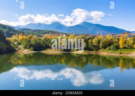 Bansko, Bulgarien Herbst Panorama Hintergrund der Pirin Berggipfel, Wasser See, bunte grüne, rote und gelbe Bäume Reflexion Stockfoto