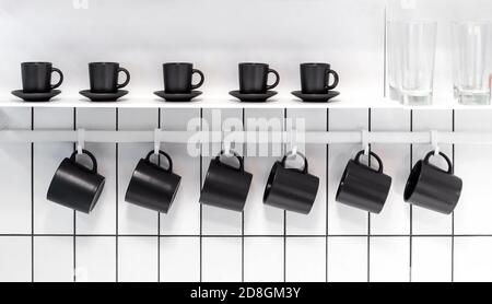 Viele Teebecher und Kaffeetassen in einer weißen Küche. Stockfoto