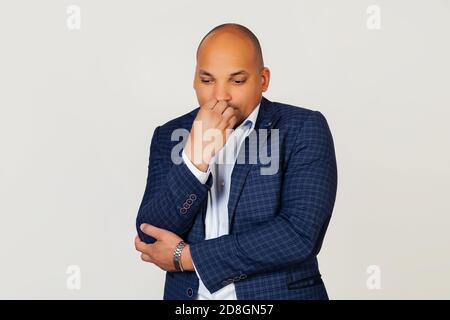 Porträt eines verärgert jungen afroamerikanischen Geschäftsmann Kerl, sieht angespannt und nervös mit Händen auf den Lippen, beißen seine Nägel. Angstproblem. Stehen auf einem grauen Hintergrund Stockfoto