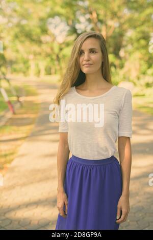 Schöne Frau mit langen Haaren stehen, beim Denken in den Weg der friedlichen, grünen Park Stockfoto