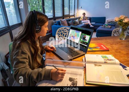 Homeschooling, Mädchen, 11 Jahre alt, zu Hause lernen, zu Hause lernen, Unterricht zu Hause, Fernunterricht, Chat mit Lehrern und Mitschülern über Laptop, Stockfoto