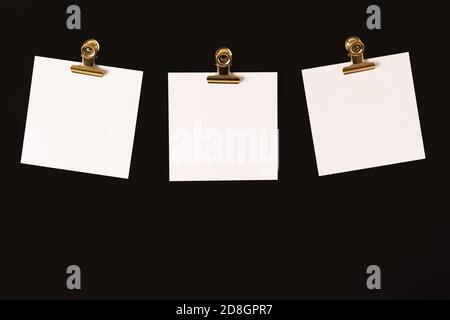 Verschiedene Tags mit Platz für Text auf schwarzem Hintergrund mit goldenen Clips. Stockfoto
