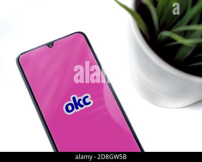 LOD, Israel - 8. Juli 2020: Moderner minimalistischer Büroarbeitsplatz mit schwarzem Smartphone mit OkCupid App Launch Screen mit Logo auf weißem Hintergrund Stockfoto