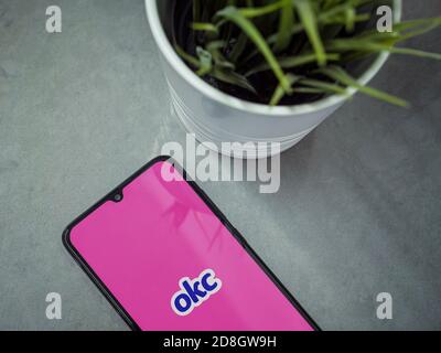 LOD, Israel - 8. Juli 2020: Moderner minimalistischer Büroarbeitsplatz mit schwarzem Smartphone mit OkCupid App Launch Screen mit Logo auf einer Marmorrückseite Stockfoto