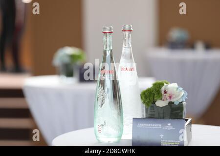 --FILE--Flaschen Wasser mit tollem Design, produziert von Nongfu Spring, einem chinesischen Unternehmen für Mineralwasser und Getränke, werden für die Teilnehmer auf den Tisch gelegt Stockfoto