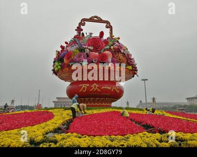 Die Menschen besuchen das Blumenbeet, das auf dem Platz des Himmlischen Friedens für den bevorstehenden Nationalfeiertag in Peking, China, am 23. September 2020 eingerichtet wurde. Stockfoto