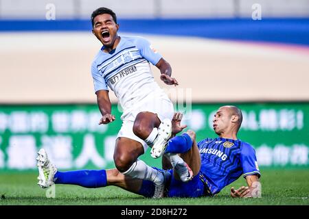 Der brasilianische Fußballspieler Renato Ribeiro Calixto oder Renatinho von Guangzhou R&F F.C., links, fällt im elften Spiel von 2020 Chinesen zusammen Stockfoto