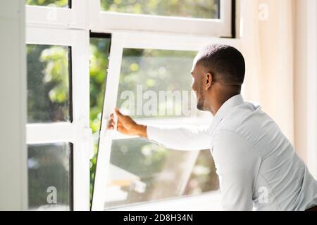 Frische Luft Aus Dem Fenster. Seitenansicht Des Mannes Entspannend Stockfoto
