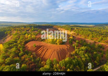 Gant, Ungarn - Luftaufnahme der verlassenen Bauxitmine, Bauxitformation. Rote und orangefarbene Oberfläche, Bauxit-Textur. Warme Herbstfarben. Stockfoto