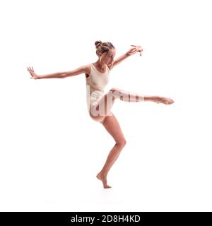 Junge schöne Tänzerin in beige Badeanzug posiert Stockfoto