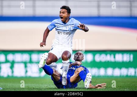 Der brasilianische Fußballspieler Renato Ribeiro Calixto oder Renatinho von Guangzhou R&F F.C., links, fällt im elften Spiel von 2020 Chinesen zusammen Stockfoto