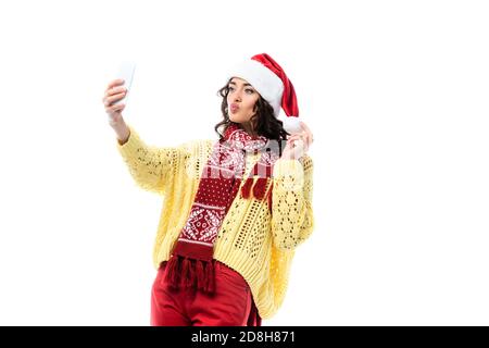 Junge Frau mit Entengesicht, in santa Hut und Schal Selfie auf Smartphone isoliert auf weiß Stockfoto