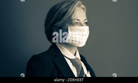 Reife Geschäftsfrau in Schutzmaske. Porträt eines modernen Geschäftsreisenden im Studio. Quarantänekonzept Stockfoto