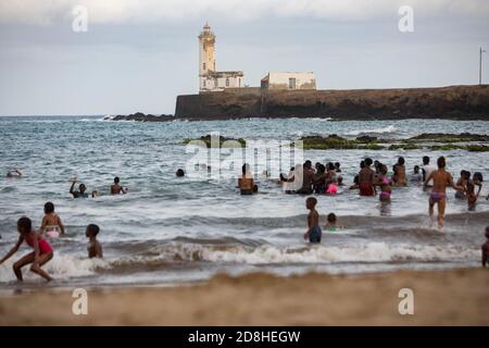 Strandgänger schwimmen in der Nähe eines Leuchtturms auf der Insel Santa Maria in Praia, Santiago, Kap Verde. Stockfoto