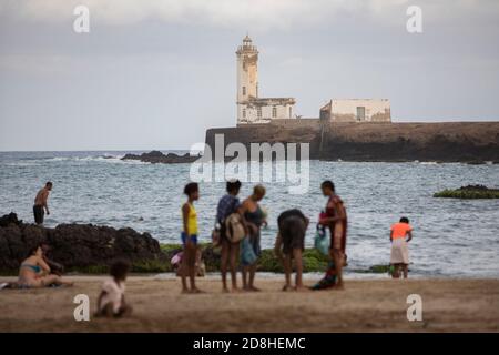 Strandgänger schwimmen in der Nähe eines Leuchtturms auf der Insel Santa Maria in Praia, Santiago, Kap Verde. Stockfoto