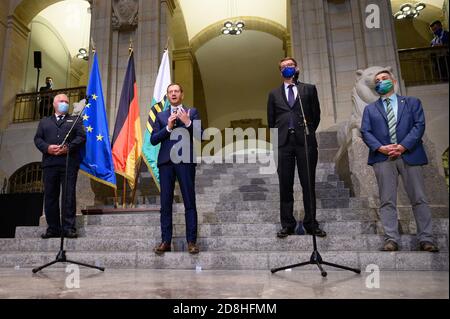 Dresden, Deutschland. Oktober 2020. Horst Kretzschmar (l-r), Staatspolizeipräsident, Michael Kretschmer (CDU), Ministerpräsident von Sachsen, Roland Wöller (CDU), Innenminister von Sachsen, und Hagen Husgen, Landesvorsitzender der Sächsischen Polizeigewerkschaft, stehen bei einem Festakt in der Staatskanzlei für die letzte Ausbildung in der Sächsischen Wachpolizei. Quelle: Sebastian Kahnert/dpa-Zentralbild/ZB/dpa/Alamy Live News Stockfoto