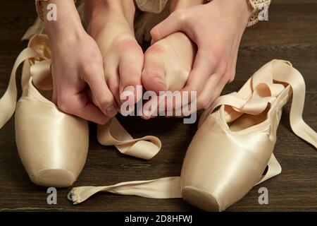 Weibliche Ballerina Füße mit Spitzen nach dem Tanz auf einem Holzboden Nahbild Stockfoto