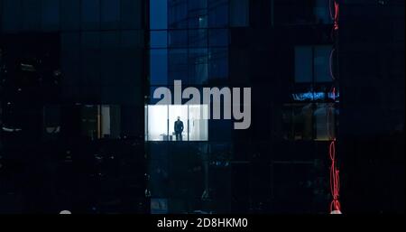 Luftaufnahme: Von draußen ins Bürogebäude mit Geschäftsmann, der aus dem Fenster schaut. Schöne Aufnahme des Finanzgeschäftsviertels Stockfoto