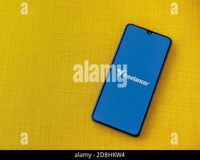 LOD, Israel - 8. Juli 2020: Freiberufler App Launch Screen mit Logo auf dem Display eines schwarzen Smartphone auf einem gelben Stoff Hintergrund. Draufsicht Stockfoto