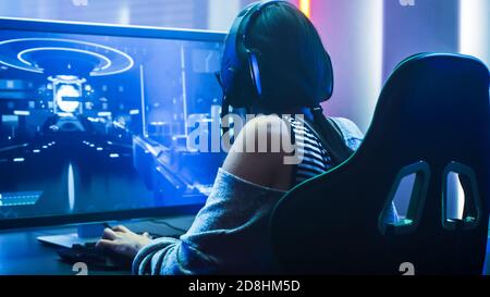 Shot von der schönen Pro Gamer Girl spielt in First-Person Shooter Online-Video-Spiel auf ihrem PC. Casual Cute Geek trägt Brille und Stockfoto