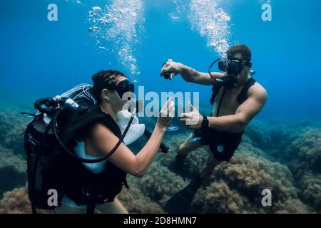 20. August 2020. Anapa, Russland. Einige Taucher gleiten unter Wasser in transparentem blauem Meer. Tauchen im Meer Stockfoto