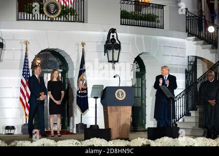 US-Präsident Donald Trump applaudiert Amy Coney Barrett und ihrem Mann Jesse Barrett während der Vereidigung in der Zeremonie auf dem South Lawn des Weißen Hauses am 26. Oktober 2020 in Washington, DC. Stockfoto