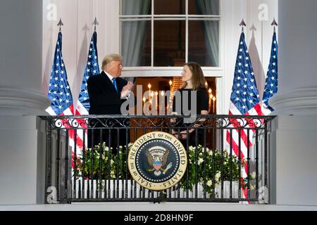 US-Präsident Donald Trump applaudiert Amy Coney Barrett vom Blue Room Balcony des Weißen Hauses, der Richterin des Obersten Gerichtshofs, nach der Vereidigung am 26. Oktober 2020 in Washington, DC. Stockfoto