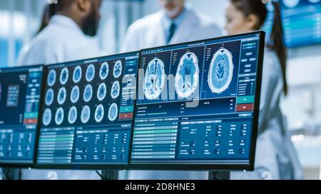 Computerbildschirm mit MRT, CT-Bild-Scan des Gehirns. Im Hintergrundgespräch des Teams der Medizinischen Wissenschaftler im Labor für Hirnforschung Stockfoto
