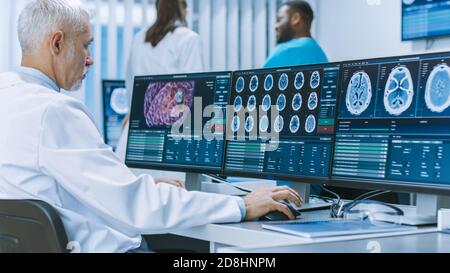 Erfahrener Senior Scientist, der mit CT MRI Brain Scan Bildern auf einem Personal Computer im Labor arbeitet. Neurologen Neurowissenschaftler in der Medizin Stockfoto