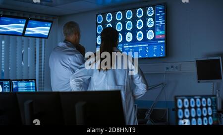 Zwei Medizinwissenschaftler Neurologen, reden und arbeiten an einem Personal Computer im modernen Labor. Forscher machen neue Entdeckungen in Stockfoto