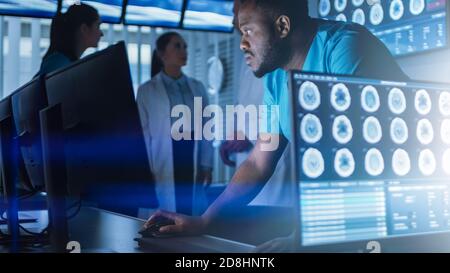 Neurologe mit einem männlichen Wissenschaftler, der an einem Personal Computer im modernen Labor arbeitet. Forscher machen neue Entdeckungen in den Bereichen Stockfoto