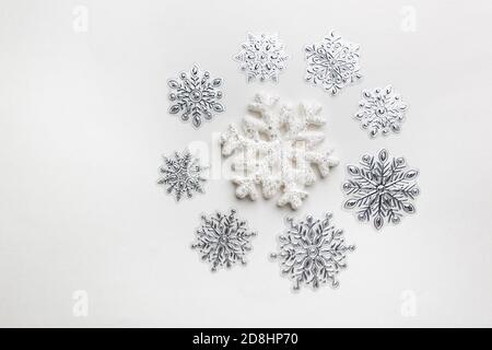 Weihnachtliche runde Komposition aus Schneeflocken auf weißem Hintergrund. Weihnachtskonzept. Flach liegend, Draufsicht. Stockfoto