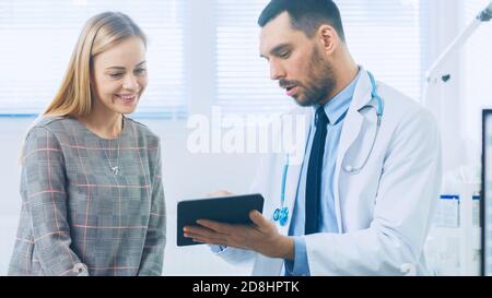 Schöne Frau besucht Arztpraxis, Er zeigt Tablet-Computer mit ihrer medizinischen Geschichte diskutieren sie ihre Gesundheit und andere medizinische Fragen. Modern Stockfoto